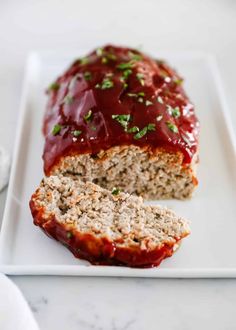 meatloaf with ketchup on a white plate