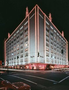 the building is lit up at night with lights on it's sides and windows