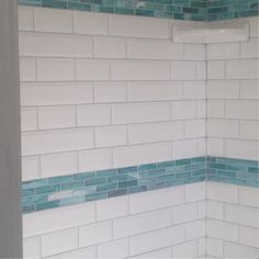 a bathroom with blue and white tiles on the walls, shower head and toilet seat