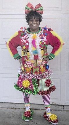 a man dressed up like a clown standing in front of a garage door