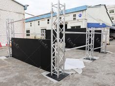 an outdoor stage set up in the middle of a parking lot with white tarp covering it