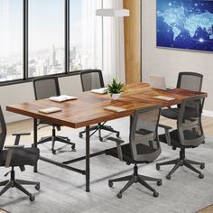 an office table with six chairs and a laptop on it in front of a large window