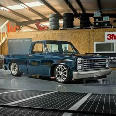 an old blue truck parked in a garage