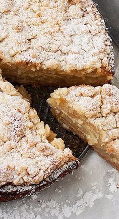 a cake with powdered sugar on top is sitting on a table next to a knife