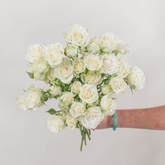 a person holding a bouquet of white roses