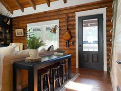 a living room filled with furniture and wooden walls