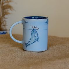 a blue coffee mug with a drawing of a dolphin on it