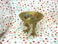 a bowl filled with chocolates sitting on top of a polka dot covered table cloth