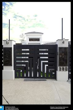 a black and white gate is in front of a house