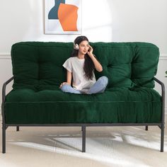 a woman sitting on top of a green couch