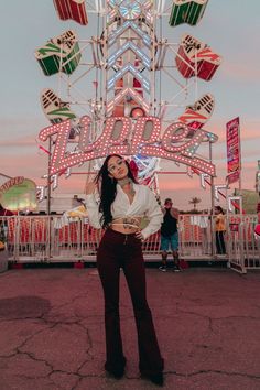 a woman standing in front of a carnival ride