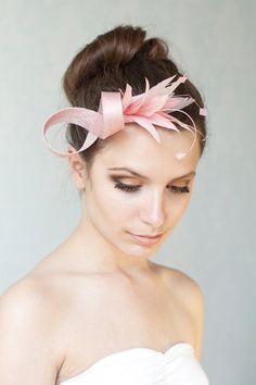 a woman in a white dress with a pink bow on her head and hair comb