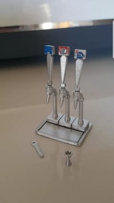 three miniature metal objects are on a table