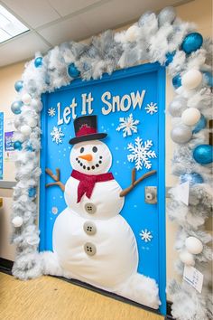 a snowman door decorated with blue and white decorations for the holiday season in an office cubicle