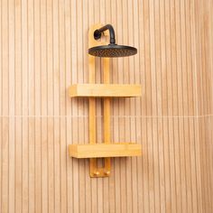 a shower head and hand held shower faucet on a wooden wall next to a tiled floor