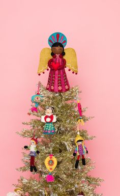 a small christmas tree with ornaments on it and an angel figurine hanging from the top