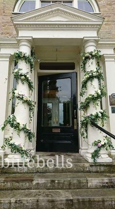 an entrance to a building with flowers growing on the front door and steps leading up to it