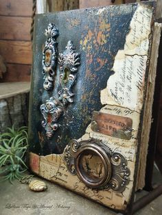 an old book is sitting on a table with some shells and other things around it