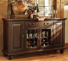 a wooden cabinet with wine glasses and bottles on top