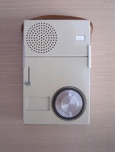 an old fashioned radio sitting on top of a wooden table next to a paper bag