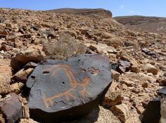 a rock that has been carved into the side of a mountain with a horse painted on it