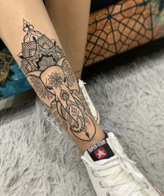 an elephant tattoo on the leg of a woman