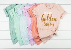 "Golden Birthday Shirt, Womens Golden Birthday Shirt, Gold Birthday Shirt, Boys Golden Birthday Shirt - Personalized Golden Birthday The perfect T Shirt to Celebrate your Golden Birthday! The t shirt will be Heathered Peach as shown in the main photo unless another color is requested from the color chart in the photos. You can choose to add a Name and/or Age to the back of the shirt from the \"Style\" drop down menu. \"It's My\" will be printed in White font, and Golden Birthday printed in Gold Golden Birthday Shirt, Flower Girl Shirts, Gold Font, Golden Birthday, Birthday Boy Shirts, Birthday Girl Shirt, Flower Girl Gifts, Gold Birthday, Golden Girl