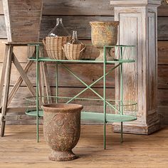 an old wooden table with baskets and vases on it