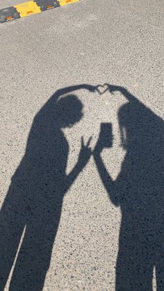 the shadow of two people standing next to each other