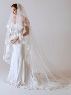 a woman in a white wedding gown and veil