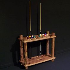 a wooden table with candles on it in front of a black wall and blue floor