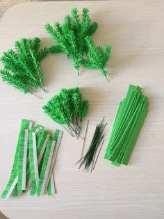 green paper flowers and sticks on a table