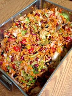 a metal pan filled with shredded vegetables on top of a wooden table