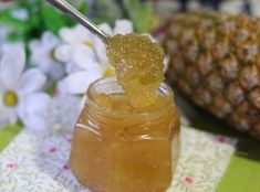 a pineapple jam in a mason jar with a spoon sticking out of the top