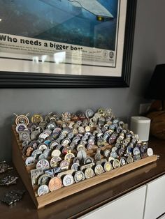 a wooden box filled with lots of different types of buttons on top of a dresser