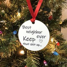 a christmas ornament that says best neighbor keep it up on a pine tree