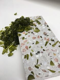 a close up of a piece of food on a table with seaweed next to it