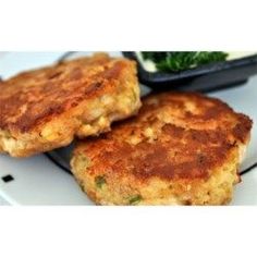 two crab cakes sitting on top of a white plate