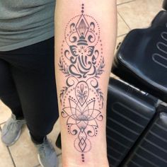 a woman's arm with a tattoo on it and an ornate design in the middle