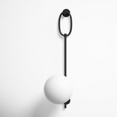 a white ball hanging from the side of a hook on a wall with a black handle