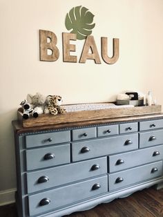 a baby's room with a dresser and teddy bear