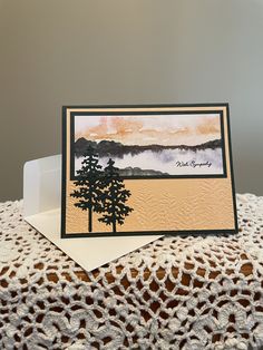 a card with a tree on it sitting on top of a doily