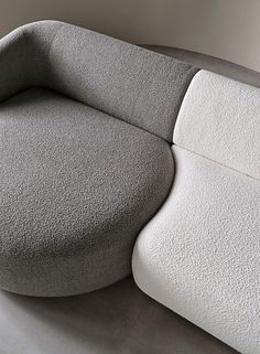 the curved couch is white and grey with a rounded seat on it's side