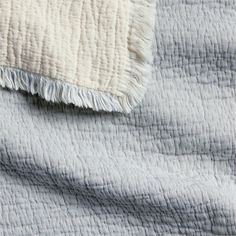 a close up view of a blanket with white and gray colors on it's edges