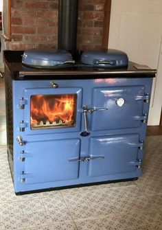 an old fashioned blue stove with flames in it