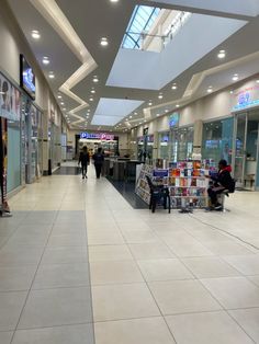 people are walking through an empty shopping mall