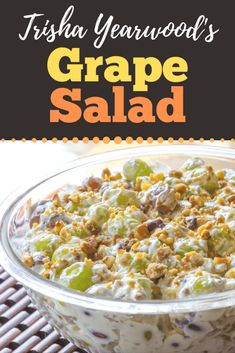 a bowl filled with grapes salad on top of a table next to an orange and black sign