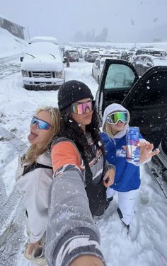 two women and a child taking a selfie in front of a car with snow on the ground