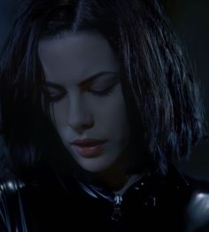 a woman with dark hair and black leather clothes