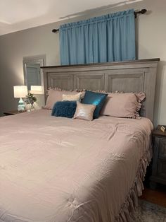 a bedroom with a bed, nightstands and blue drapes on the windowsill